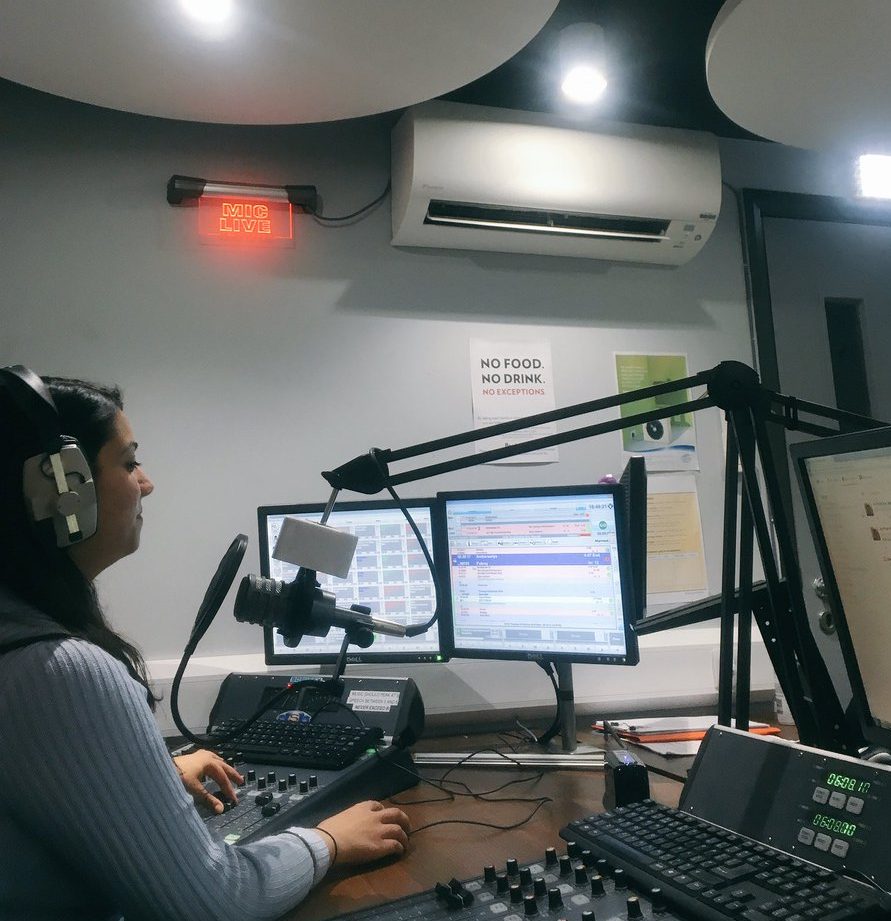 Presenter in the studio with the "Mic Live" light illuminated