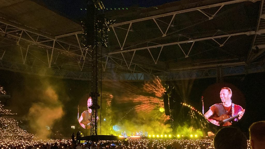 During "Yellow", the crowd's wristbands shone gold around Wembley, which made Chris Martin smile on the big screens.